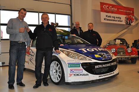 Esben Hegelund får overdraget nøgler til årets DM-vindervogn i rally af Danmarksmesteren Karl-Åge Jensen. Bag dem ses teamchef for Peugeot Sport Dealer Team DK Jens-Ole Kristiansen og årets sølvvinder Christian Jensen bag dennes vogn.